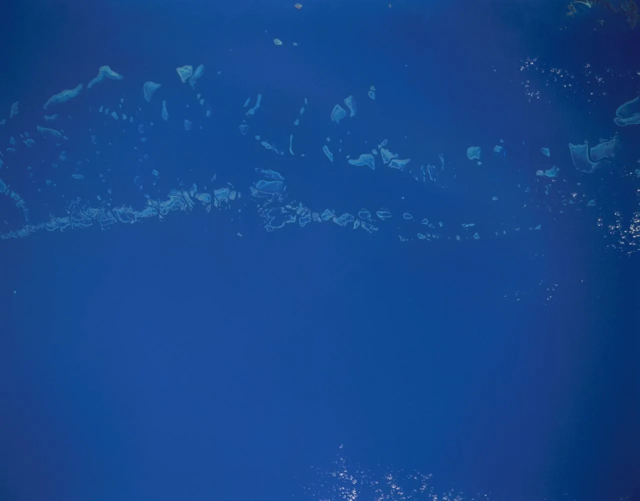 Helle Riffstrukturen des Great Barrier Reef im dunkelblauen Meer