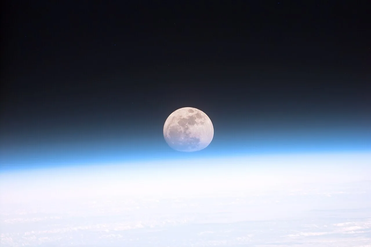 Vollmond über dem blauen Saum der Erdatmosphäre