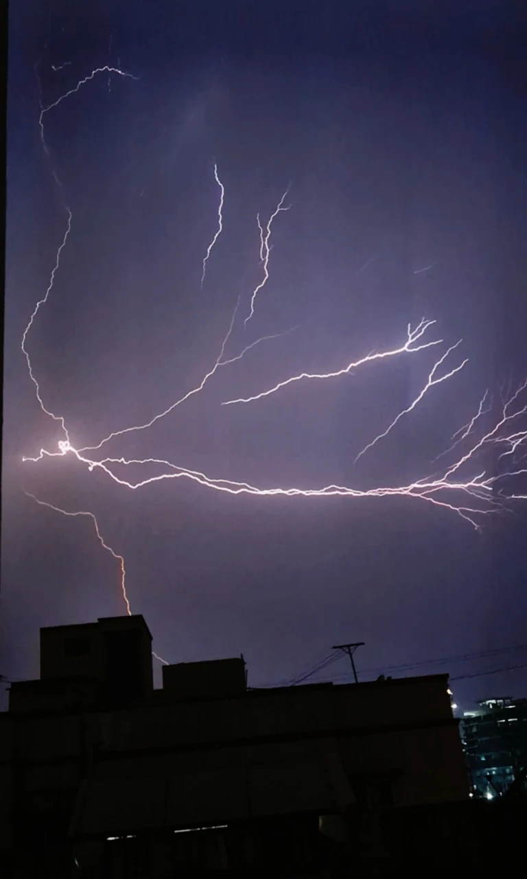 Mehrere Blitze am dunklen Himmel über einer Stadt